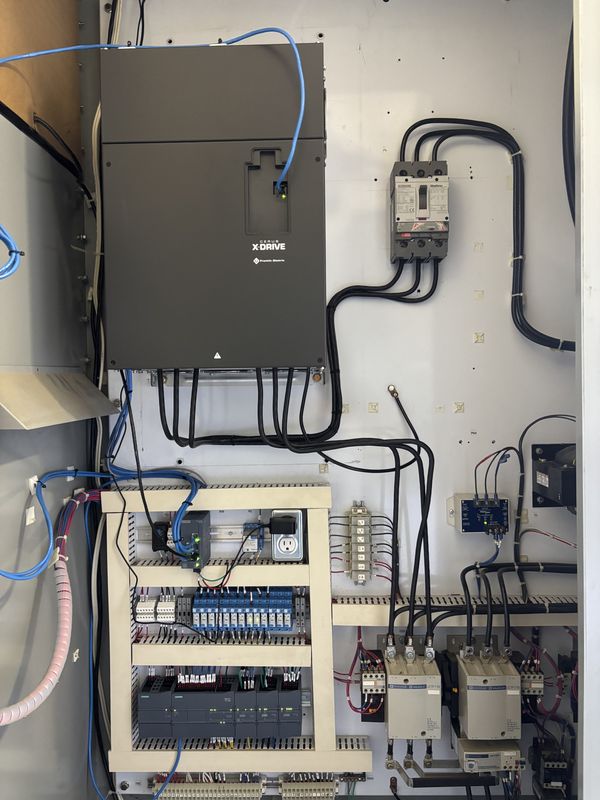 Black Cerus X-Drive mounted inside the cabinet with a new breaker beside it and the new PLC below